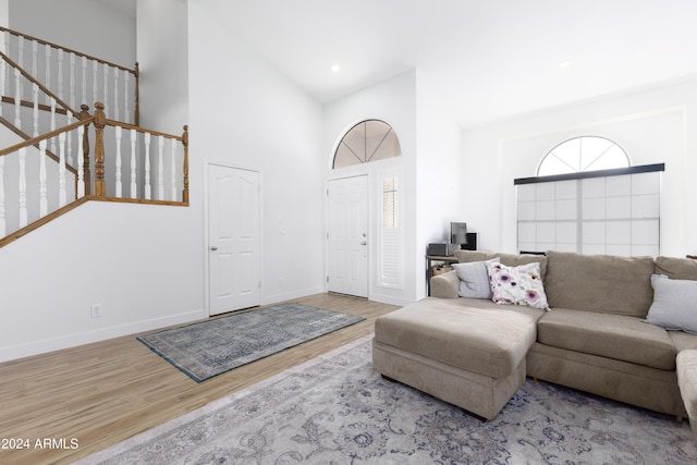 living room with high vaulted ceiling and light wood-type flooring