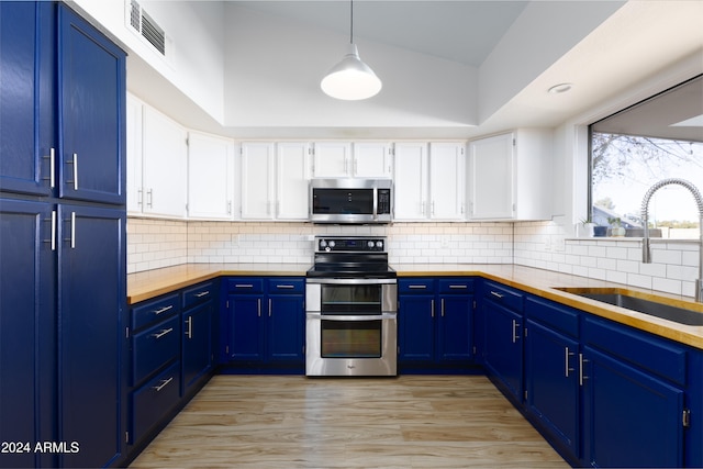 kitchen with white cabinetry, sink, blue cabinets, pendant lighting, and appliances with stainless steel finishes