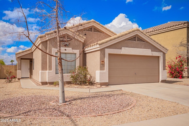 view of front of home featuring a garage, a tile roof, driveway, and stucco siding