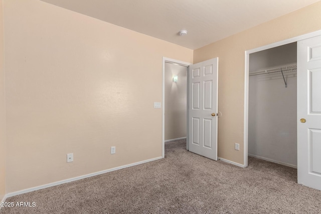 unfurnished bedroom with a closet, carpet floors, and baseboards