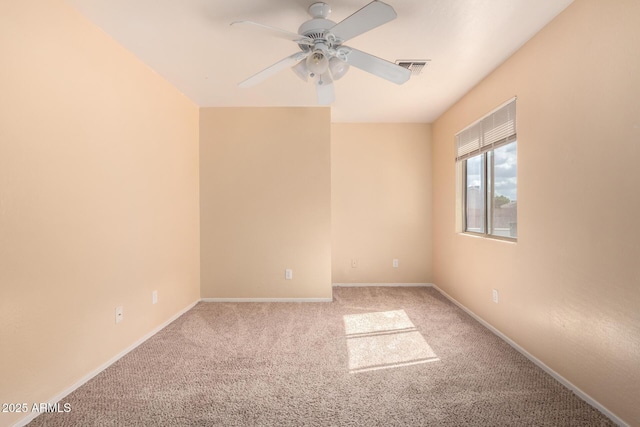 carpeted empty room featuring visible vents, baseboards, and a ceiling fan