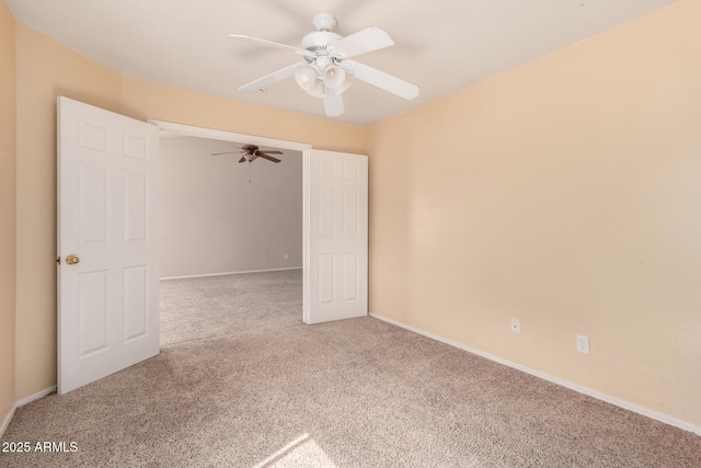 empty room featuring baseboards, carpet, and a ceiling fan