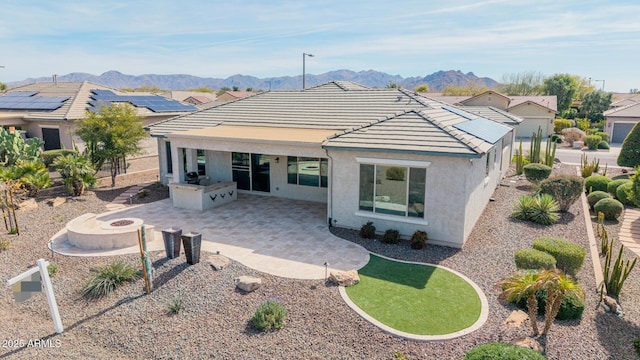 back of house with a patio, area for grilling, a fire pit, and a mountain view