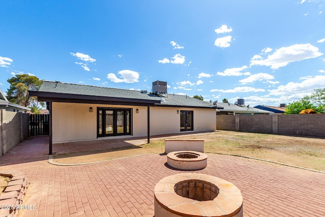 3008 W Michigan Ave, Phoenix, AZ 85053 - back of house featuring a fire pit, cooling unit, a fenced backyard, french doors, and a patio area