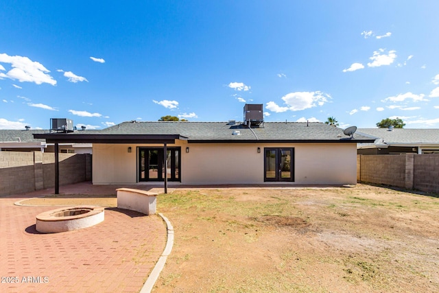 3008 W Michigan Ave, Phoenix, AZ 85053 - rear view of house featuring french doors, central AC unit, a fenced backyard, a patio, and a fire pit