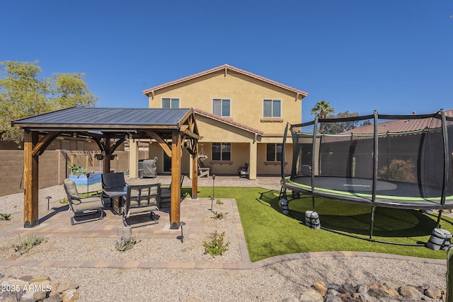 26842 N 176th Ln, Surprise, AZ 85387 - rear view of house with a patio area, a gazebo, a trampoline, a lawn, and stucco siding