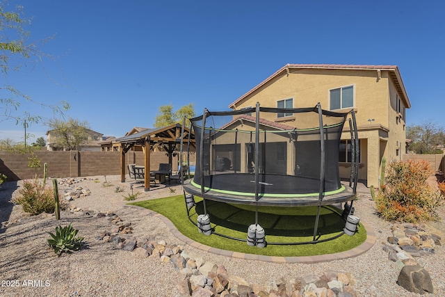 26842 N 176th Ln, Surprise, AZ 85387 - rear view of property with a trampoline, stucco siding, a patio area, a fenced backyard, and a gazebo