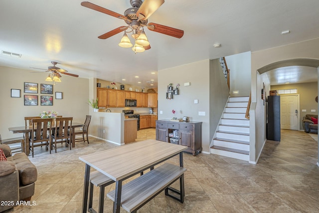 26842 N 176th Ln, Surprise, AZ 85387 - living area featuring baseboards, a ceiling fan, stairs, visible vents, and arched walkways