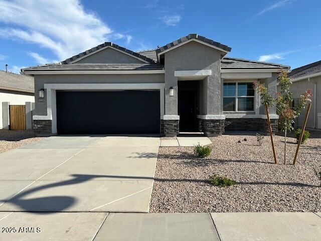 38055 W Excussare Way, Maricopa, AZ 85138 - view of front of property with a garage, driveway, stone siding, and stucco siding