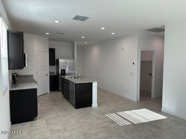 38055 W Excussare Way, Maricopa, AZ 85138 - kitchen featuring white microwave, dark cabinetry, a sink, and recessed lighting