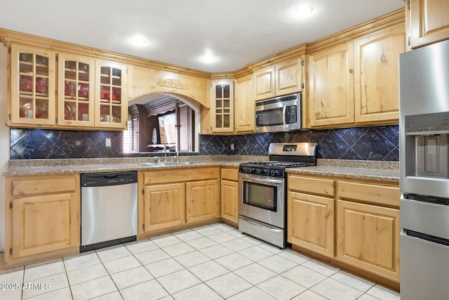 kitchen featuring light tile patterned floors, stainless steel appliances, light brown cabinets, tasteful backsplash, and sink