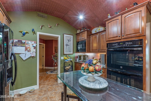 1702 W Monterosa St W, Phoenix, AZ 85015 - kitchen featuring black appliances, lofted ceiling, baseboards, and brown cabinetry