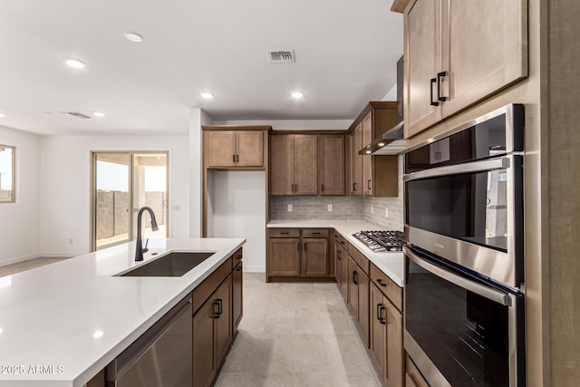 kitchen featuring a sink, stainless steel appliances, light countertops, backsplash, and recessed lighting
