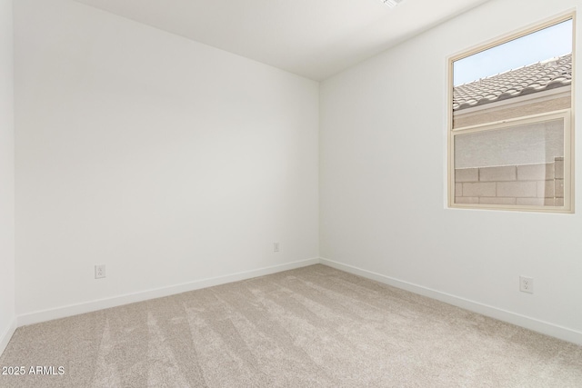 carpeted empty room with baseboards