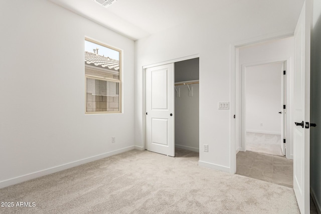 unfurnished bedroom featuring carpet floors, baseboards, and a closet