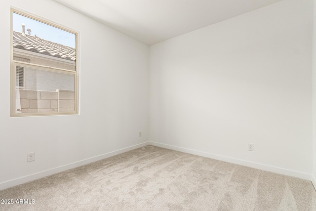 carpeted empty room with baseboards