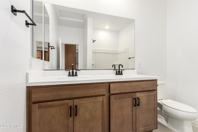 bathroom featuring toilet and double vanity