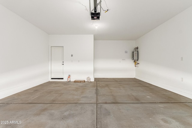 garage with a garage door opener, tankless water heater, and baseboards