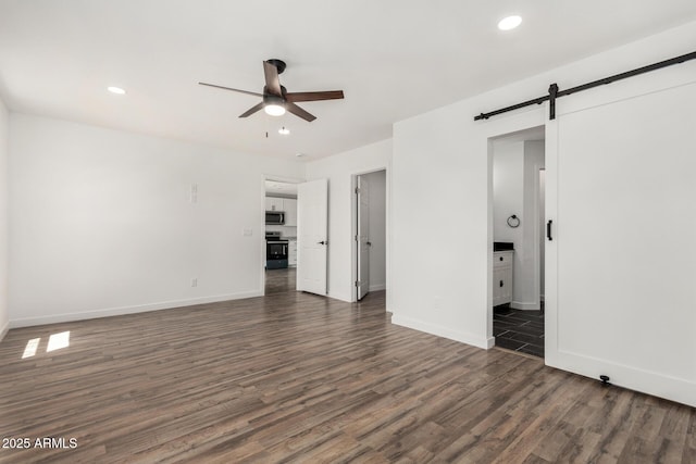 11474 N 79th Dr, Peoria, AZ 85345 - unfurnished living room with ceiling fan, a barn door, dark wood-type flooring, baseboards, and recessed lighting