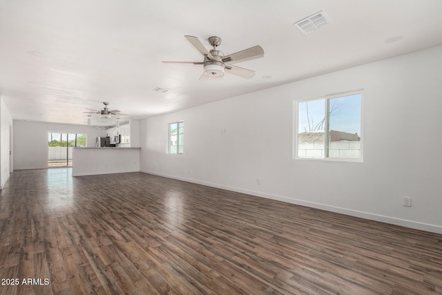11474 N 79th Dr, Peoria, AZ 85345 - unfurnished living room featuring a ceiling fan, dark wood-type flooring, healthy amount of natural light, and baseboards