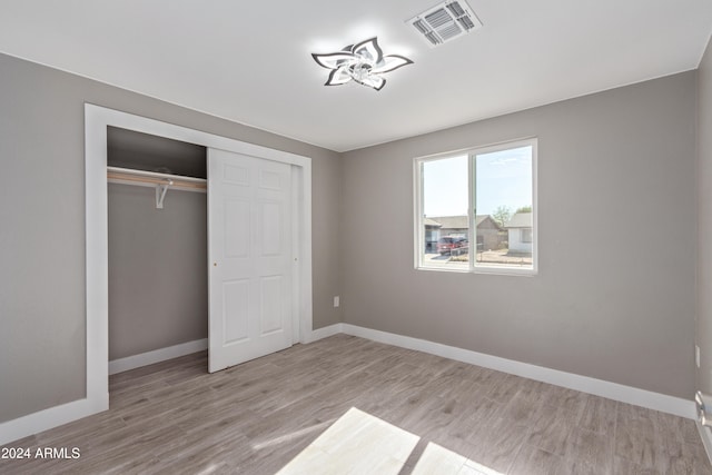 unfurnished bedroom featuring light hardwood / wood-style floors and a closet