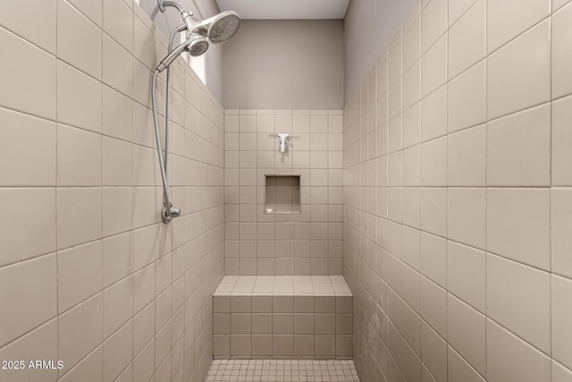 bathroom featuring a tile shower and ceiling fan