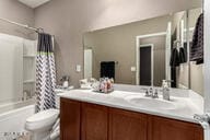 full bathroom with toilet, vanity, and shower / bathtub combination with curtain