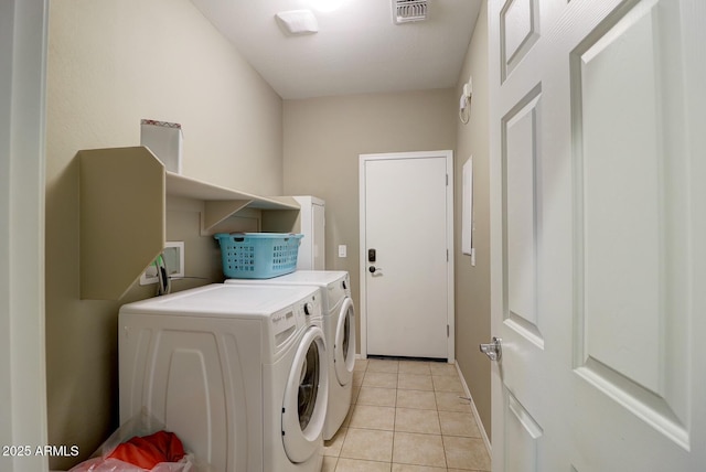 clothes washing area featuring light tile patterned flooring and independent washer and dryer