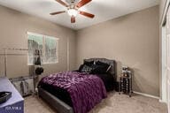 bedroom with ceiling fan and light carpet