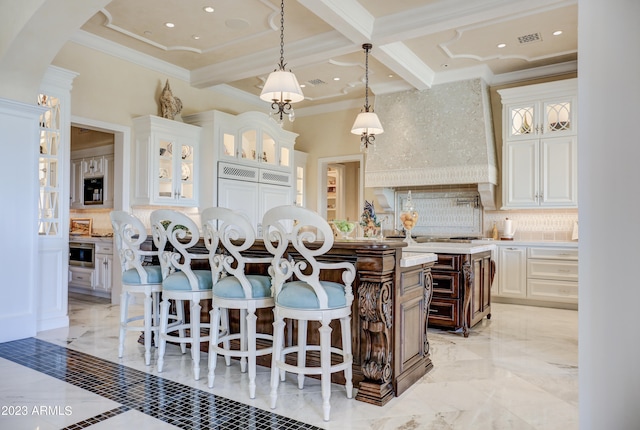 kitchen featuring decorative backsplash, a kitchen bar, white cabinetry, and pendant lighting