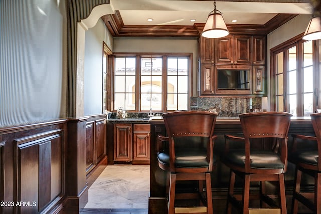 bar with pendant lighting and crown molding