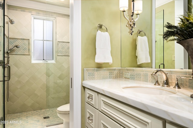 bathroom featuring vanity, toilet, and a shower with door