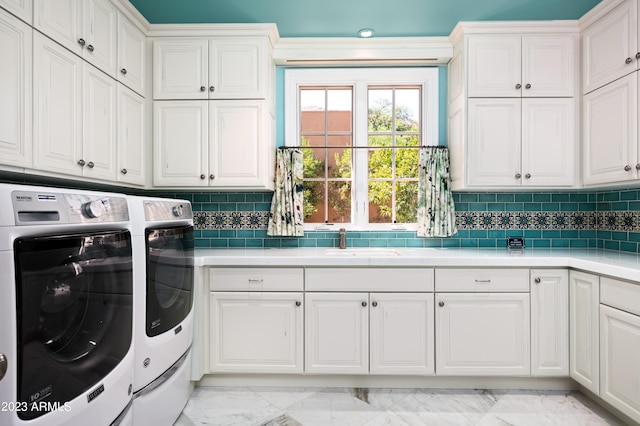 laundry room featuring sink, washer and dryer, and cabinets