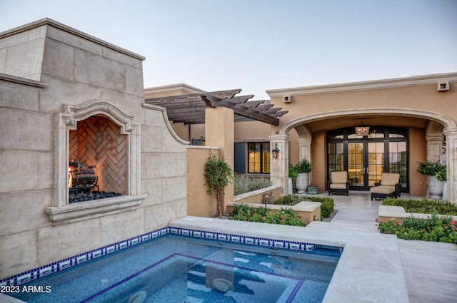 view of pool with exterior fireplace, a pergola, and a patio