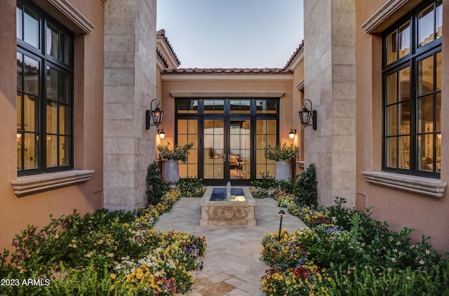 view of exterior entry featuring french doors and a patio area