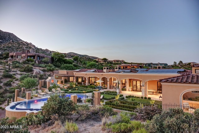 back of house featuring a patio, a mountain view, and a community pool