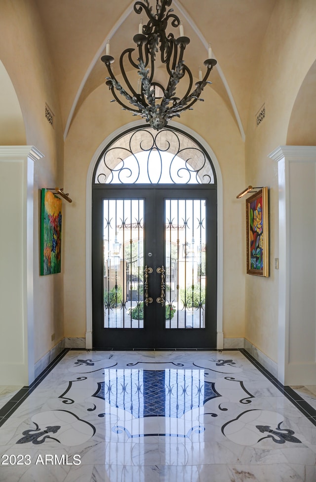 entryway featuring a towering ceiling and french doors