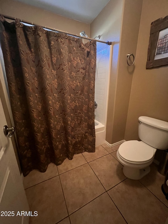 bathroom featuring tile patterned flooring, toilet, and shower / tub combo with curtain