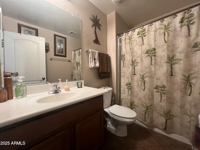 bathroom with tile patterned flooring, vanity, and toilet