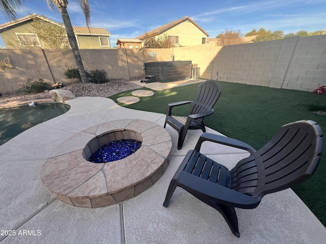 view of patio / terrace with a swimming pool with hot tub and a fire pit