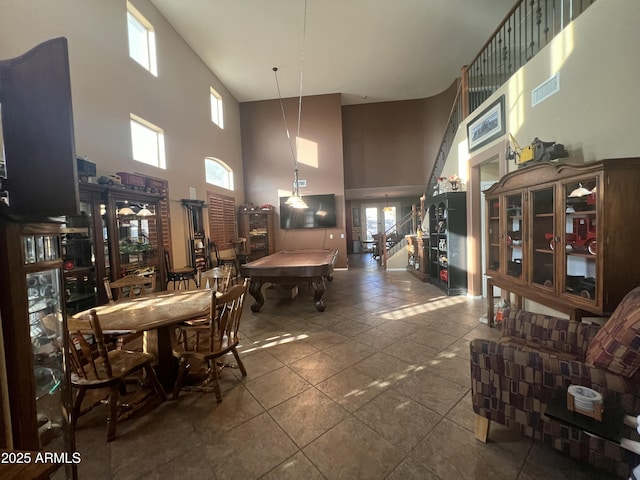 dining space with french doors, a towering ceiling, and dark tile patterned floors