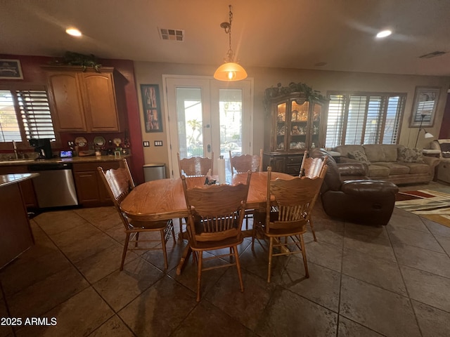 dining space featuring french doors, a healthy amount of sunlight, sink, and dark tile patterned floors