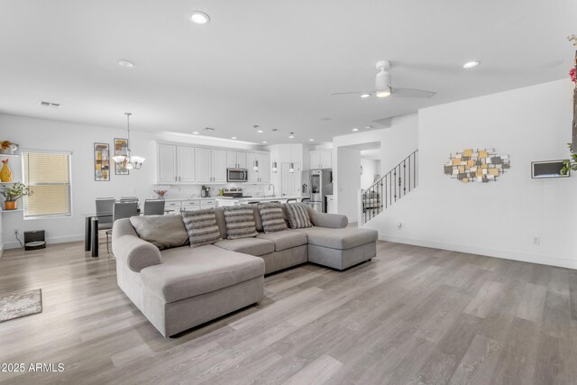 living area featuring baseboards, recessed lighting, stairs, light wood-style floors, and visible vents