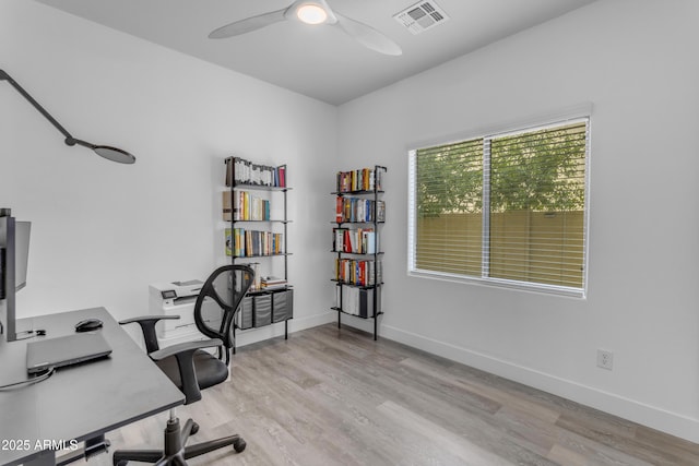 office space with visible vents, baseboards, a ceiling fan, and light wood-style floors