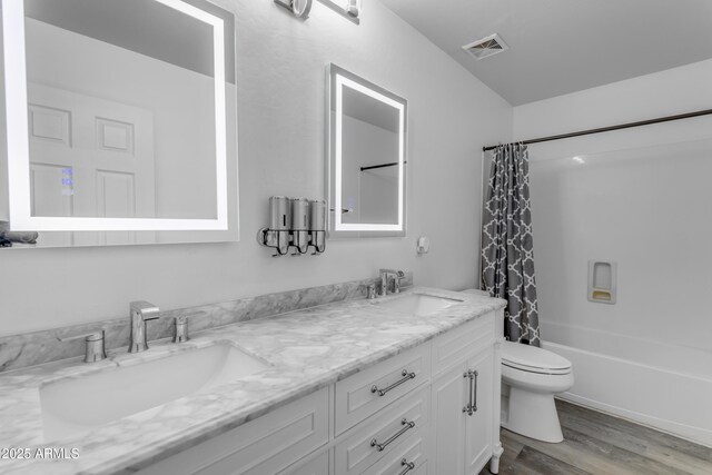 bathroom featuring visible vents, a sink, toilet, and wood finished floors