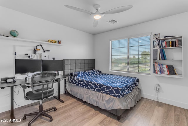bedroom featuring visible vents, baseboards, ceiling fan, and wood finished floors