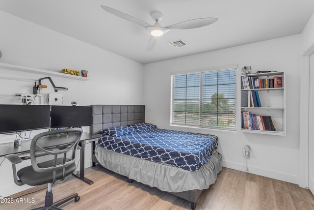 bedroom with wood finished floors, baseboards, a ceiling fan, and visible vents