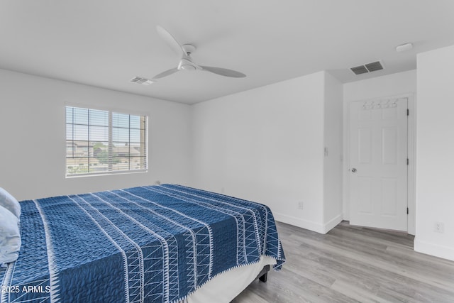 bedroom featuring visible vents, baseboards, a ceiling fan, and wood finished floors