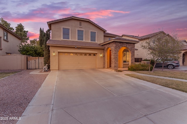 traditional-style home featuring stucco siding, fence, a tile roof, a garage, and driveway