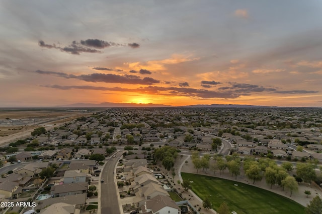 aerial view at dusk featuring a mountain view and a residential view